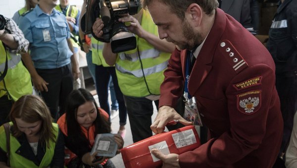 Сотрудник Роспотребнадзора демонстрирует санкционные продукты, подлежащие уничтожению